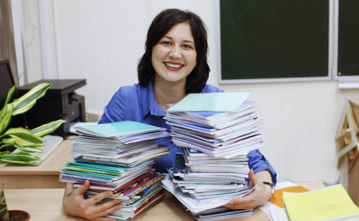 Teacher with piles of homework