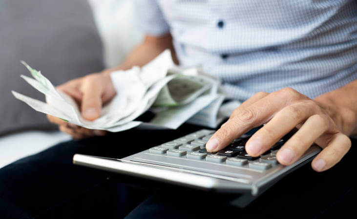 young man with bills and calculator